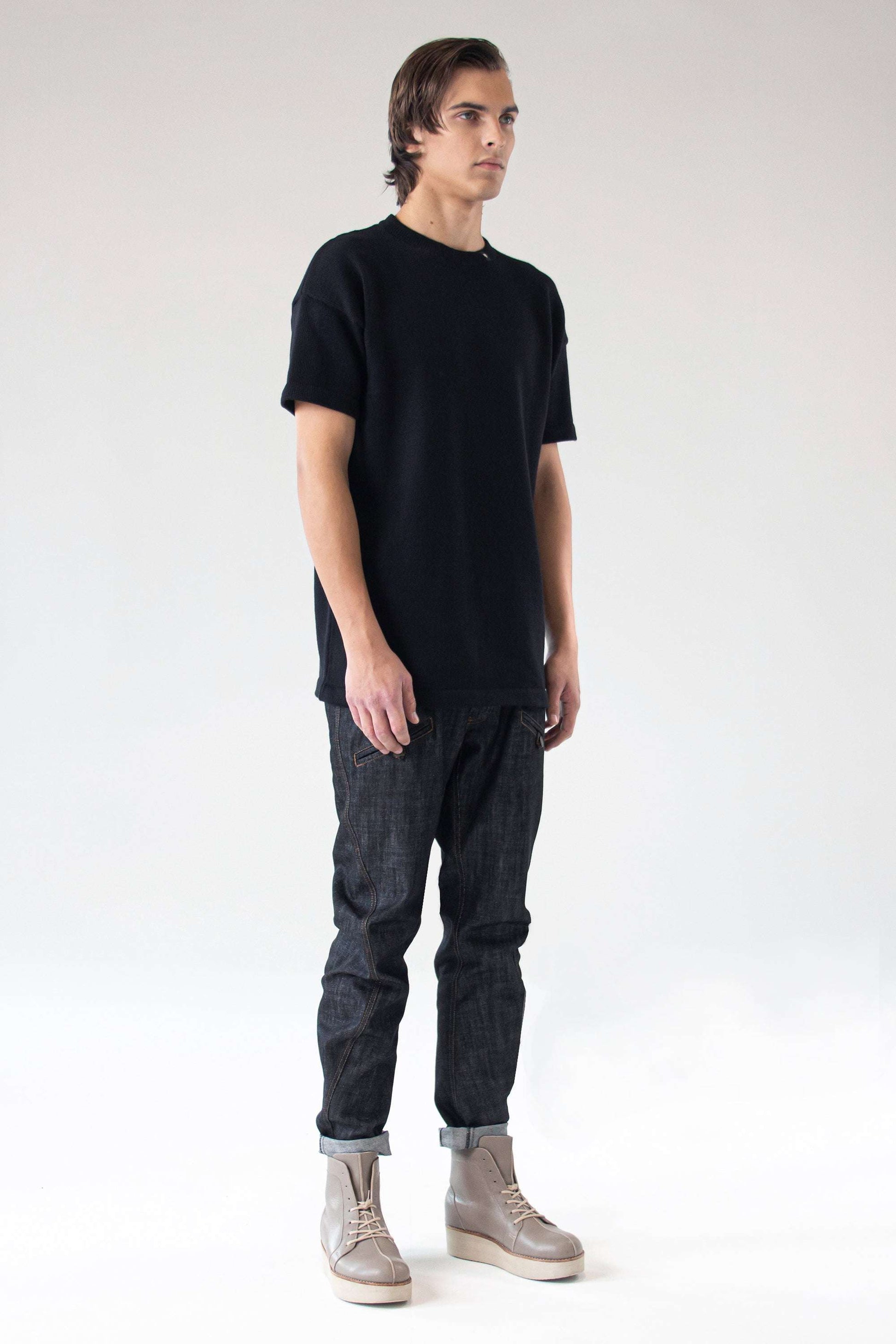 Front view of model wearing the One Wolf Knitted T-Shirt SEEKER in black, 100% cotton, unisex minimalist design